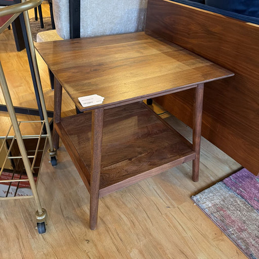 Wooden side table with a shelf on a wooden floor