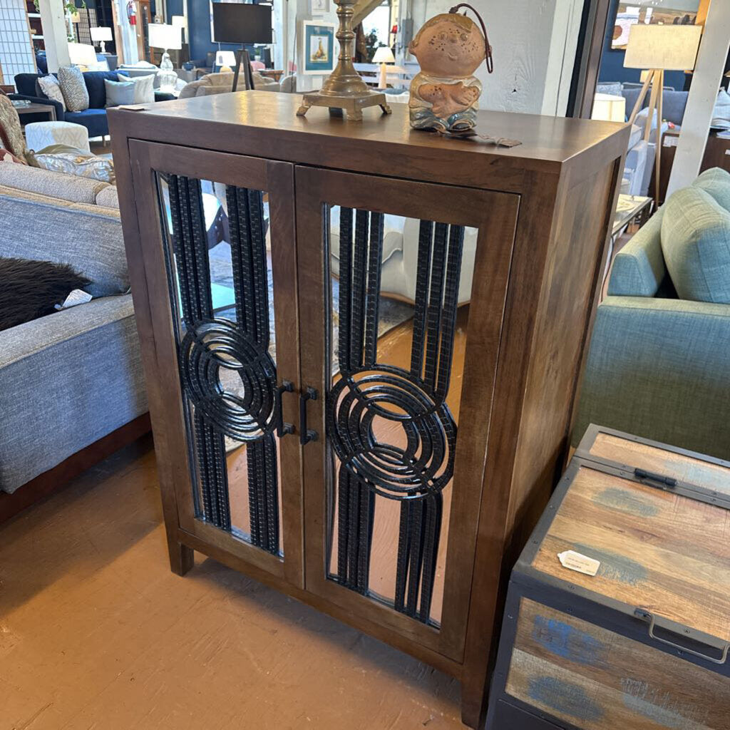 Wooden cabinet with decorative metal accents in a furniture store setting