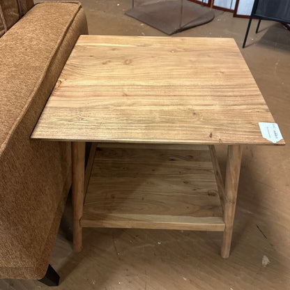 Wooden side table next to a brown sofa in an indoor setting