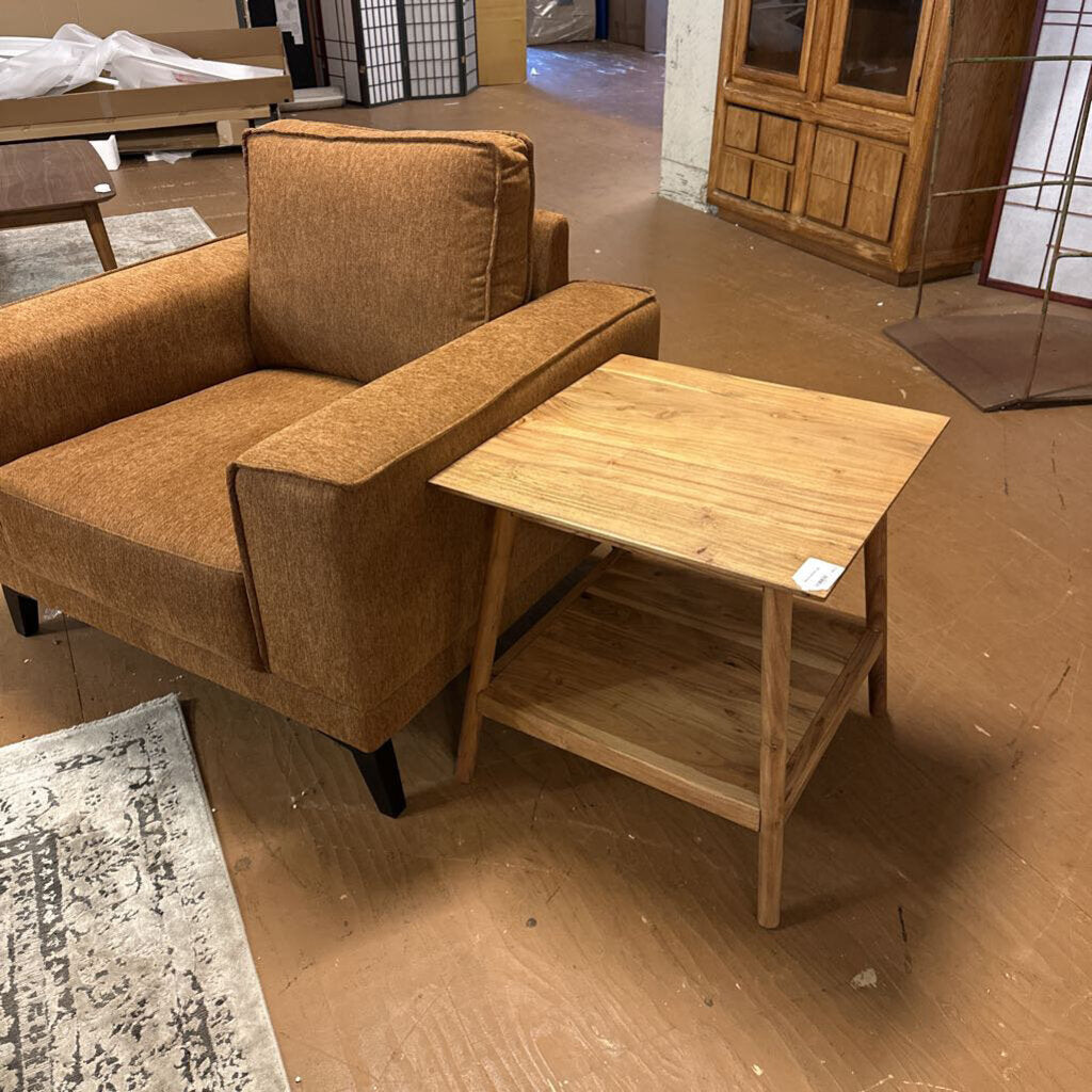 Brown sofa with a wooden side table on a brown floor.
