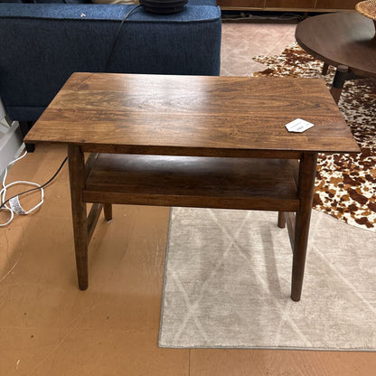 Wooden coffee table in a room with a rug and furniture.