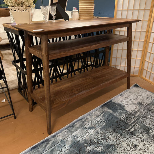 Wooden console table with shelves in a room setting