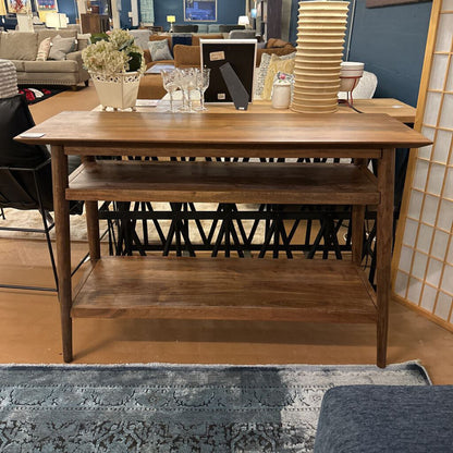 Wooden dining table with a shelf in a room with furniture and decor.