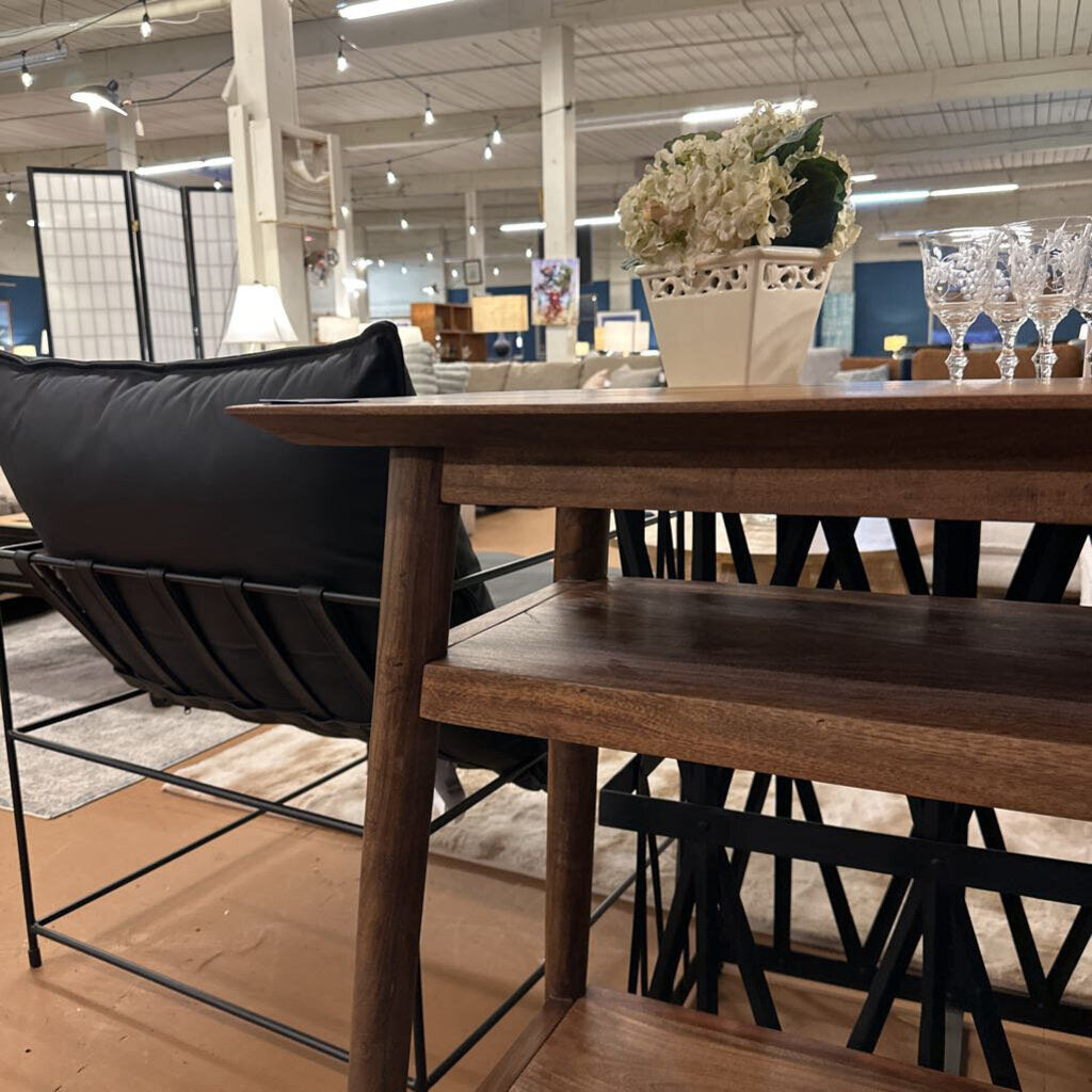 Wooden dining table with a black chair in a showroom setting