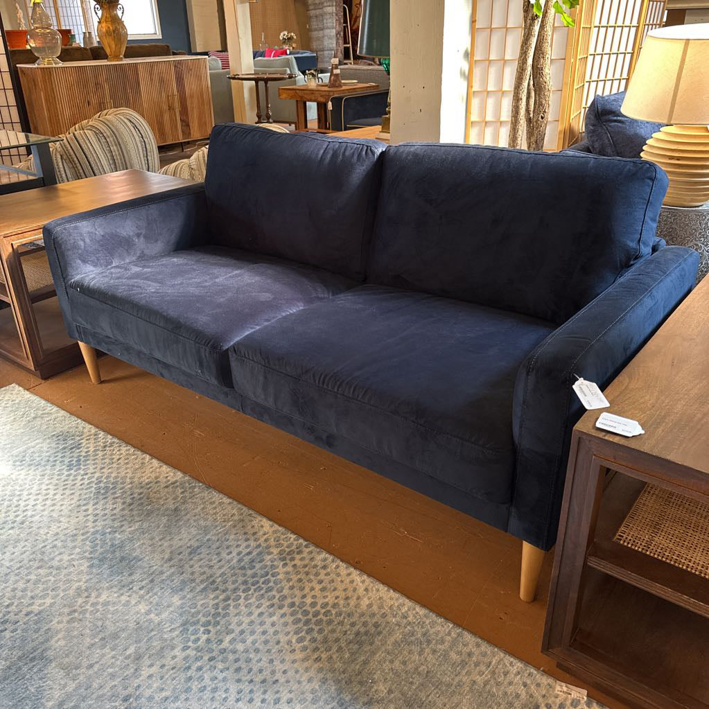 Blue sofa in a room with wooden furniture and decor