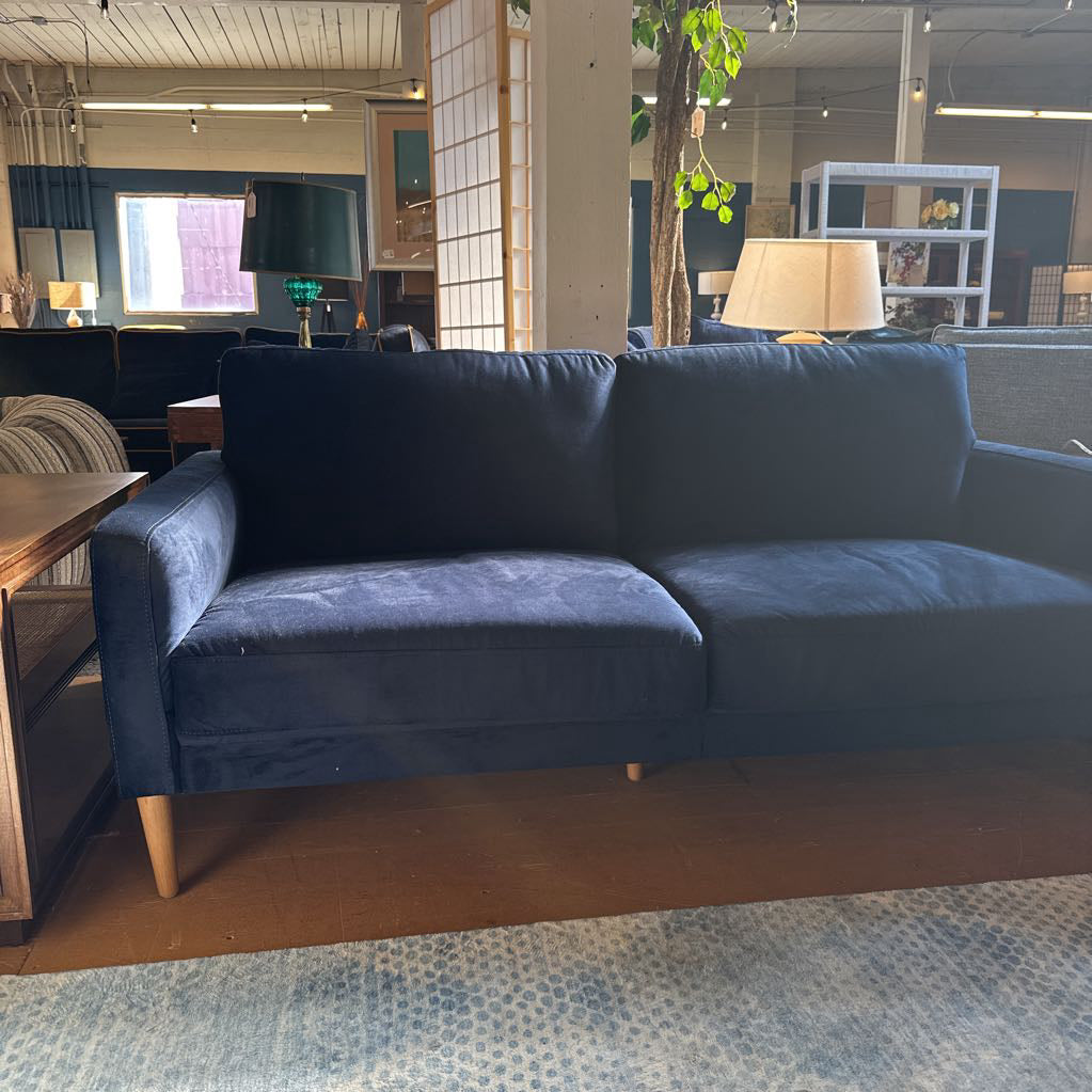Blue sofa in a room with tables and chairs