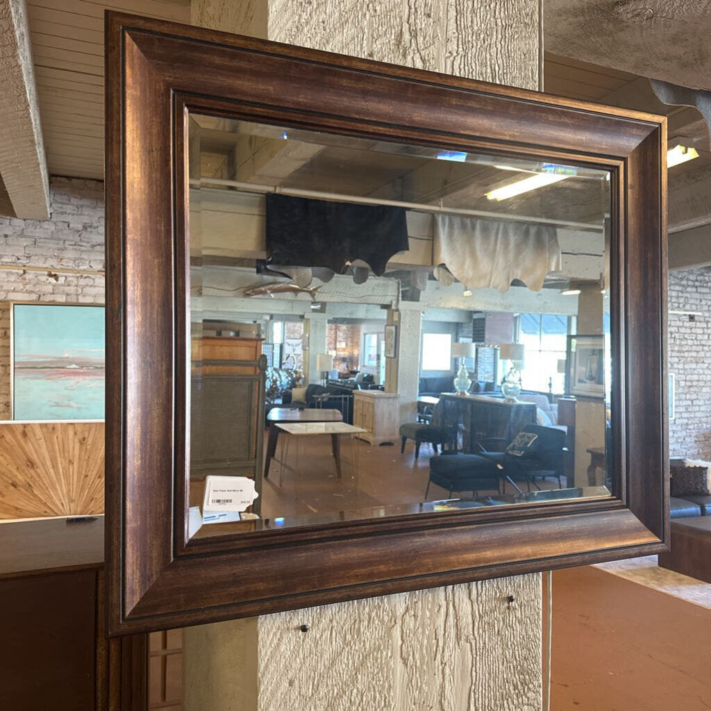 Wooden-framed mirror on a textured wall