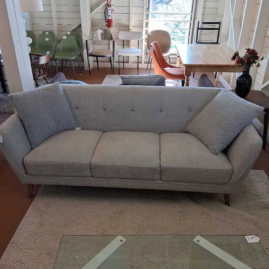 Gray sofa in a room with chairs and a table
