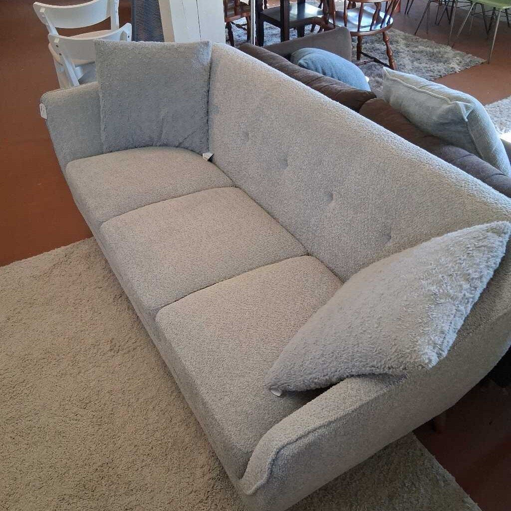 Gray sectional sofa with cushions in a living room setting