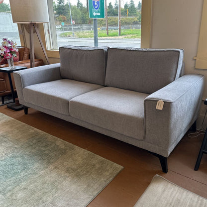 Gray sofa in a room with a window and lamp