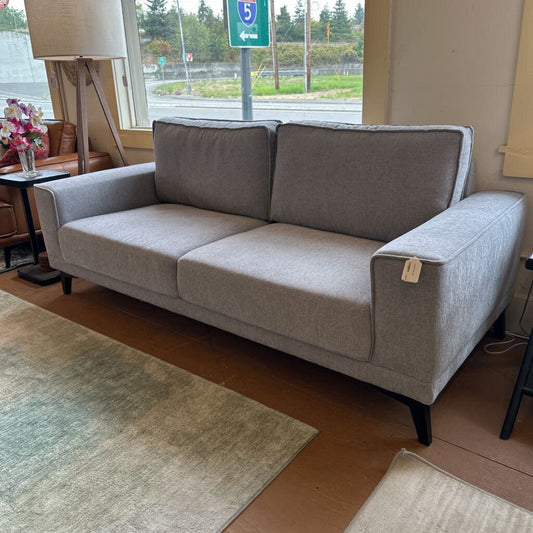 Gray sofa in a room with a window and lamp