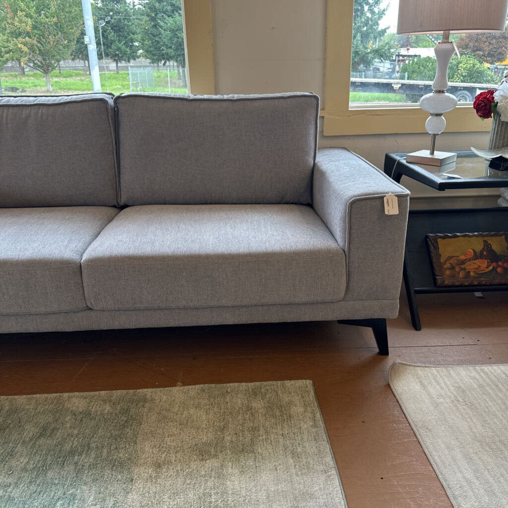 Gray sofa in a living room with a coffee table and decorative items.
