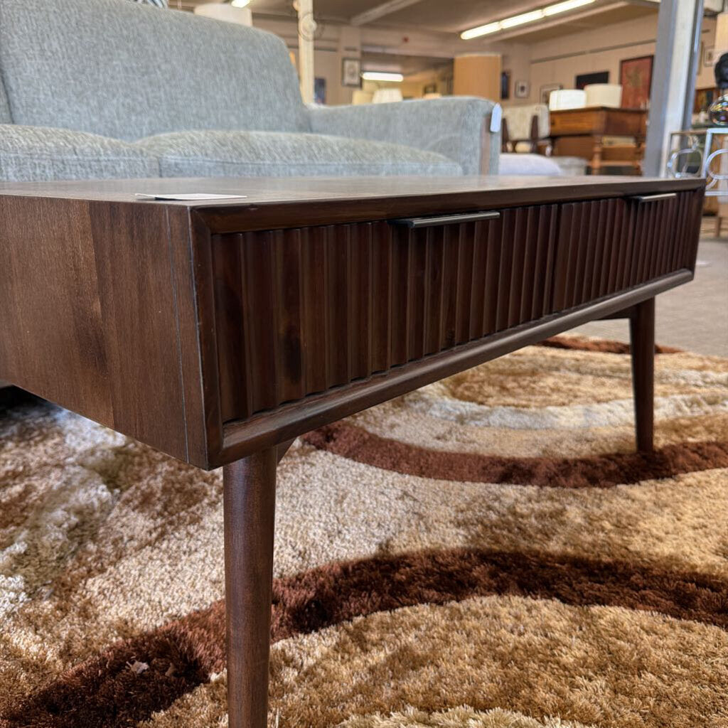 Wooden coffee table with a drawer in a furniture store setting