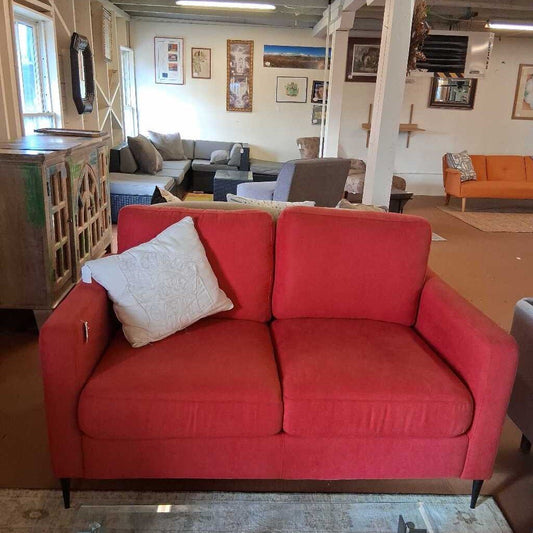 Red sofa in a room with other furniture and decor