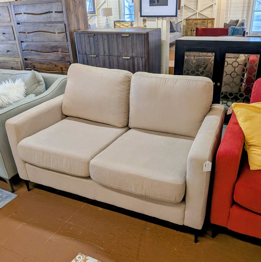 Beige sofa in a room with other furniture and decor