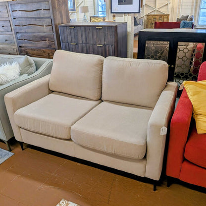 Beige sofa in a room with other furniture and decor