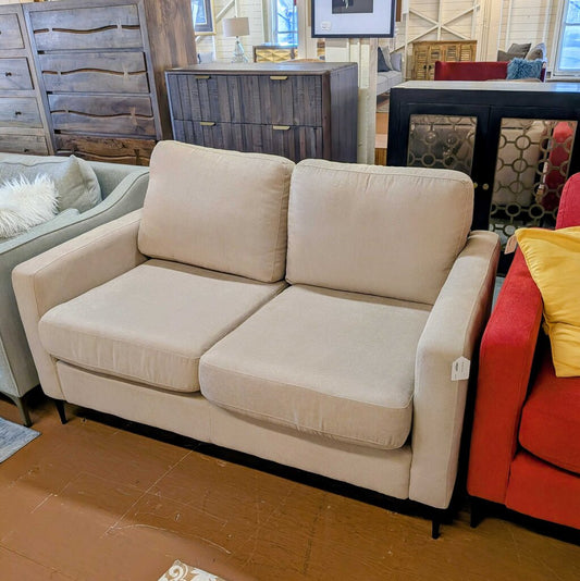 Beige sofa in a room with other furniture and decor