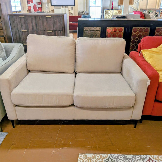 Beige sofa in a room with other furniture and decor