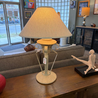 Table lamp with beige shade on a wooden table in a living room setting