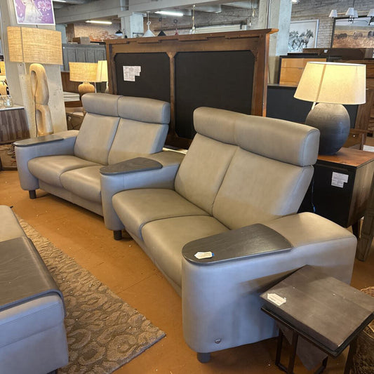 Gray sectional sofa with armrest pads in a furniture store setting