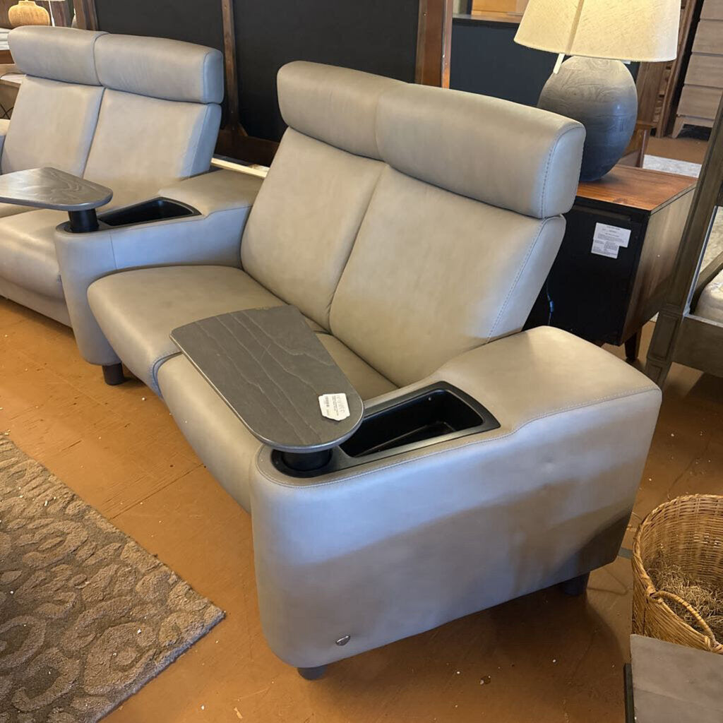 Gray recliner with cup holders and trays in a showroom setting