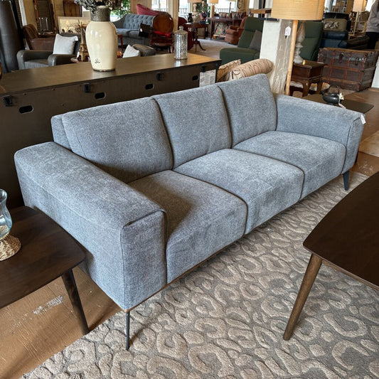 Gray sofa in a room with furniture and decor