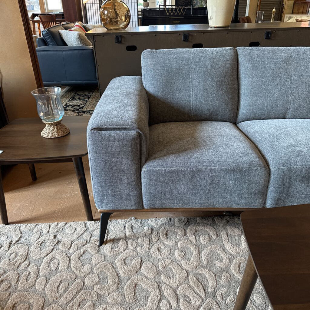 Gray sofa in a living room setting with a coffee table and decorative items.