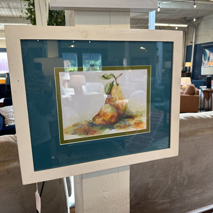 Framed artwork of pears on a stand in a store setting