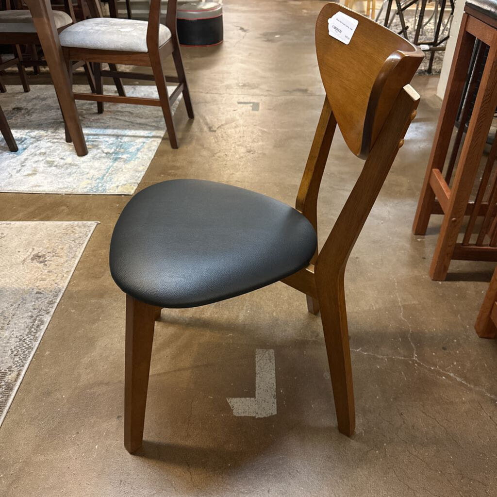 Wooden chair with a black seat on a tiled floor