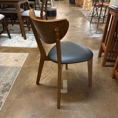 Wooden chair with a blue cushion on a tiled floor in a store setting