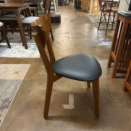 Wooden chair with a black seat in a store setting