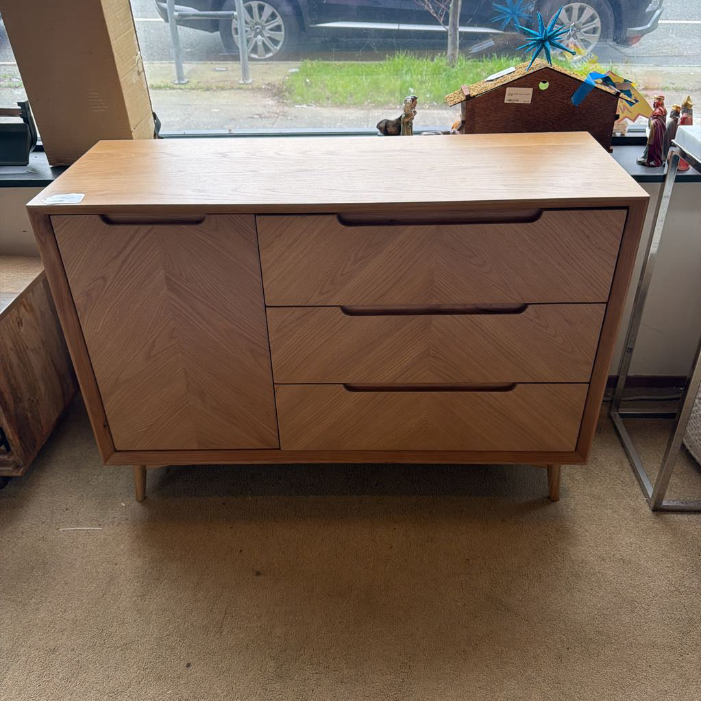 Wooden dresser with three drawers in a room with a window and car outside