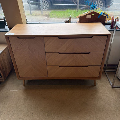 Wooden dresser with three drawers in a room with a window and car outside