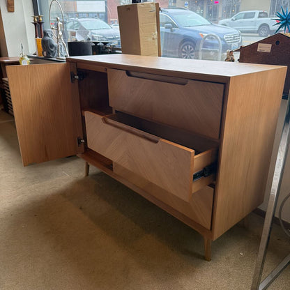 Wooden dresser with open drawer in a store setting