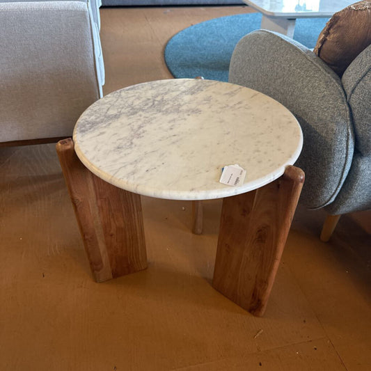 Round marble table with wooden legs in a room setting