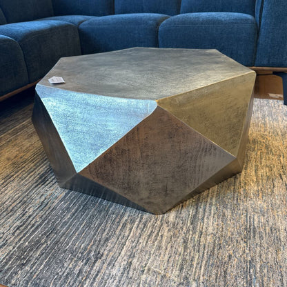 Geometric coffee table in a living room setting with a blue sofa.