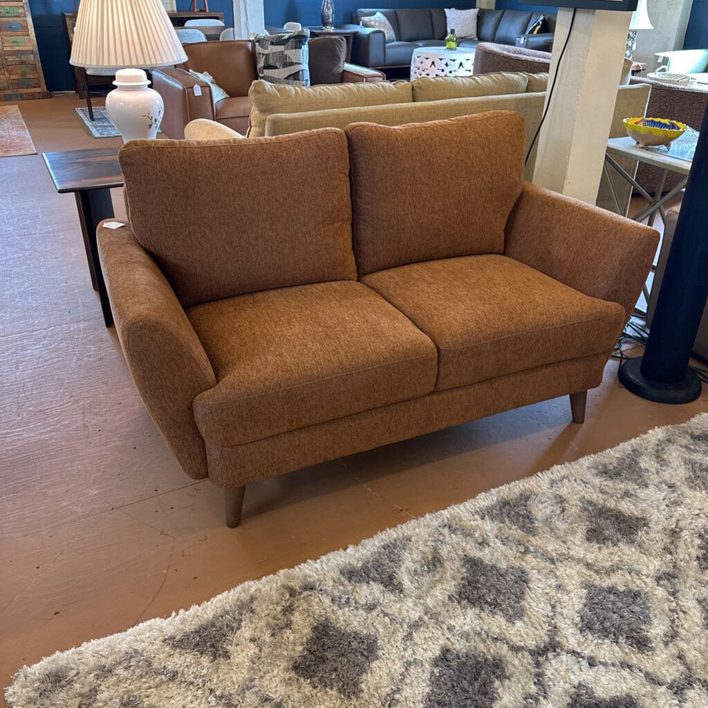 Brown sofa in a room with wooden floor and patterned rug