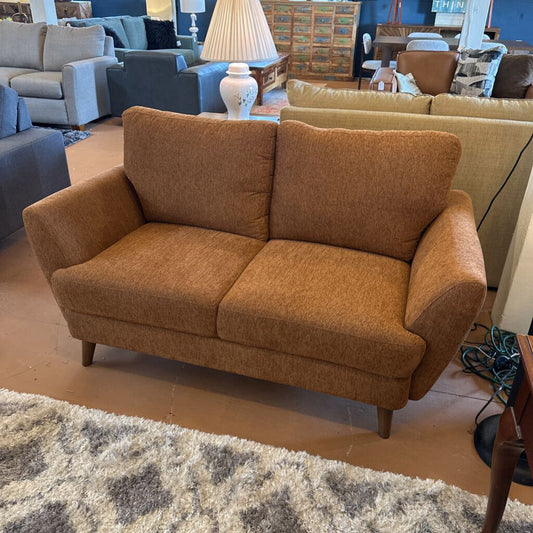 Brown sofa in a living room setting with other furniture and decor.