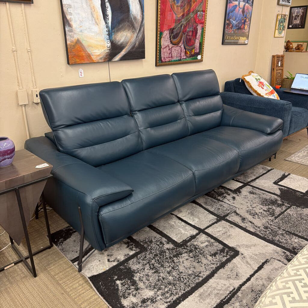 Blue leather sofa in a room with artworks on the wall
