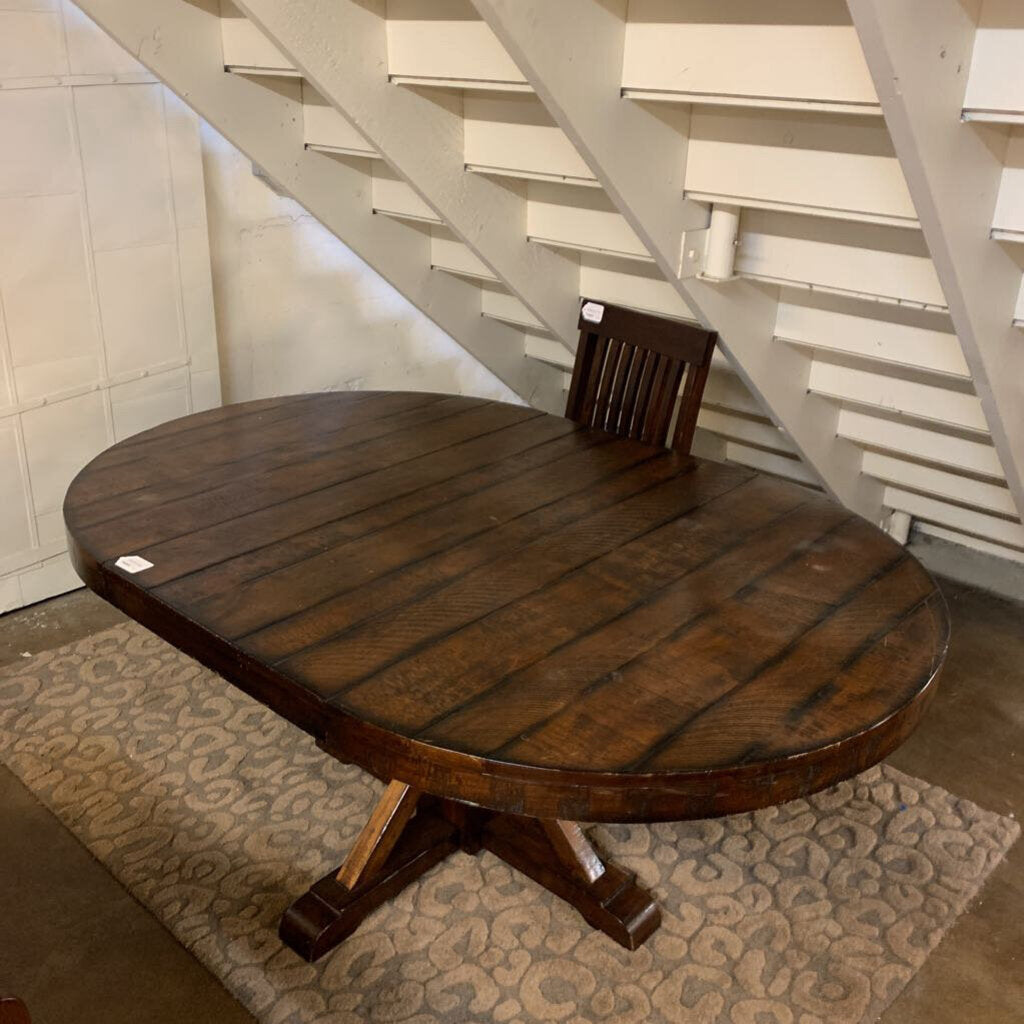 Wooden dining table with a chair underneath a staircase