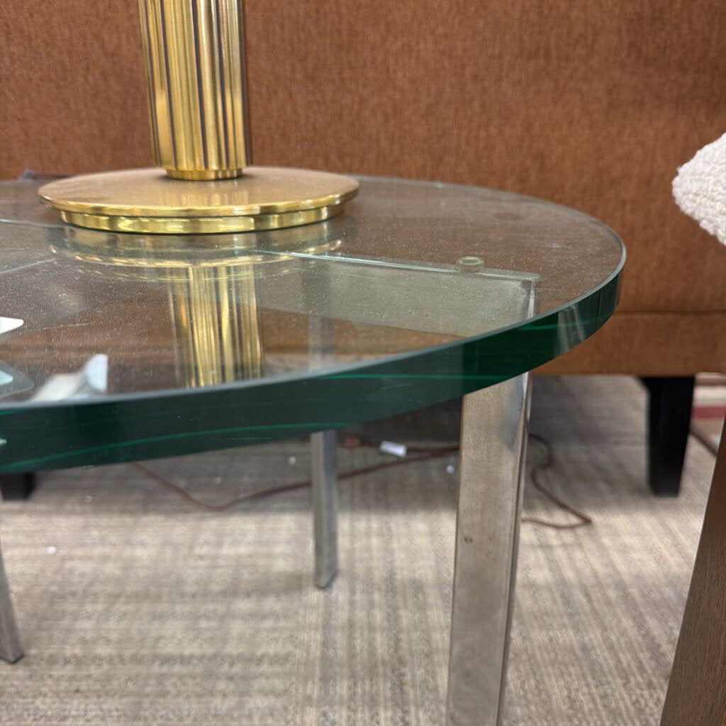 Glass table with gold base on a carpeted floor