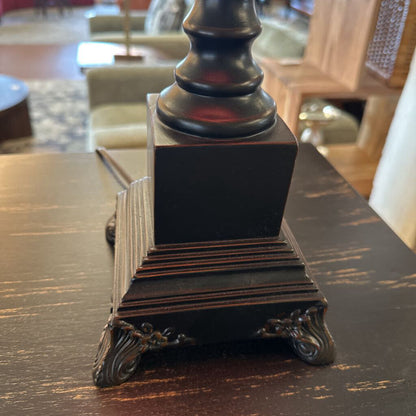 Decorative black pedestal on a wooden surface with blurred background