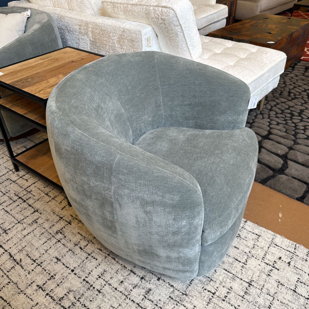 Gray armchair in a room with furniture and a rug.