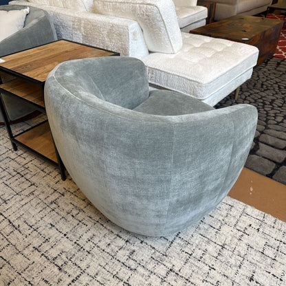 Gray armchair in a room with patterned rug and furniture