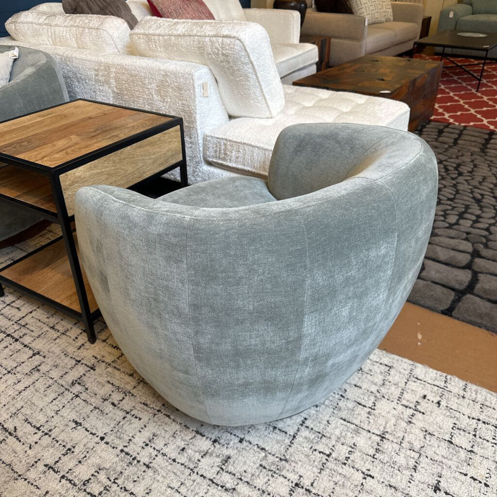 Gray armchair in a living room setting with furniture and decor.