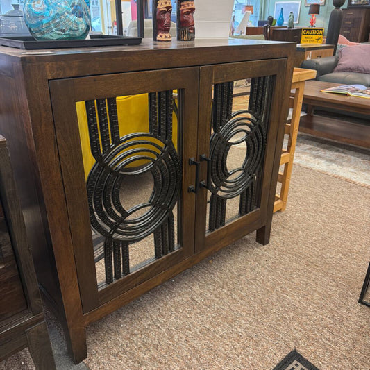 Wooden cabinet with decorative metal grilles in a store setting