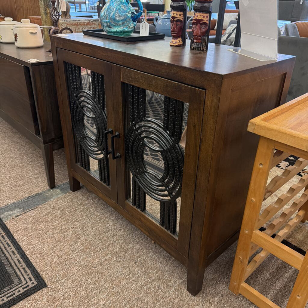 Wooden sideboard with decorative glass doors in a room setting