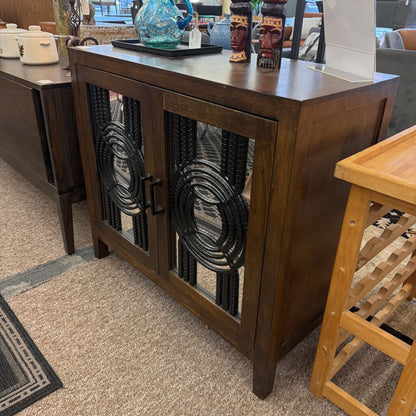 Wooden sideboard with decorative glass doors in a room setting