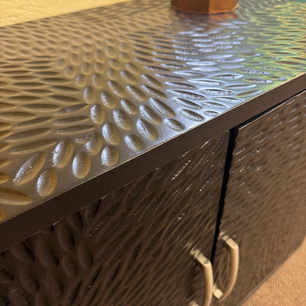 Metallic textured surface with a handle on a cabinet