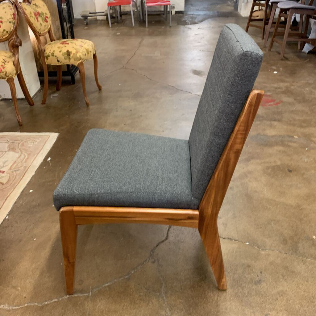 Chair with gray cushioned seat and backrest on a concrete floor.